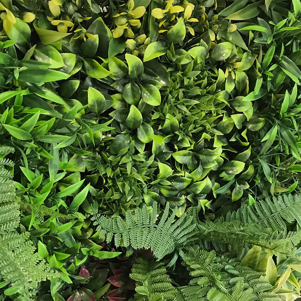 Artificial green foliage wall panel with fern-like and small leaf textures