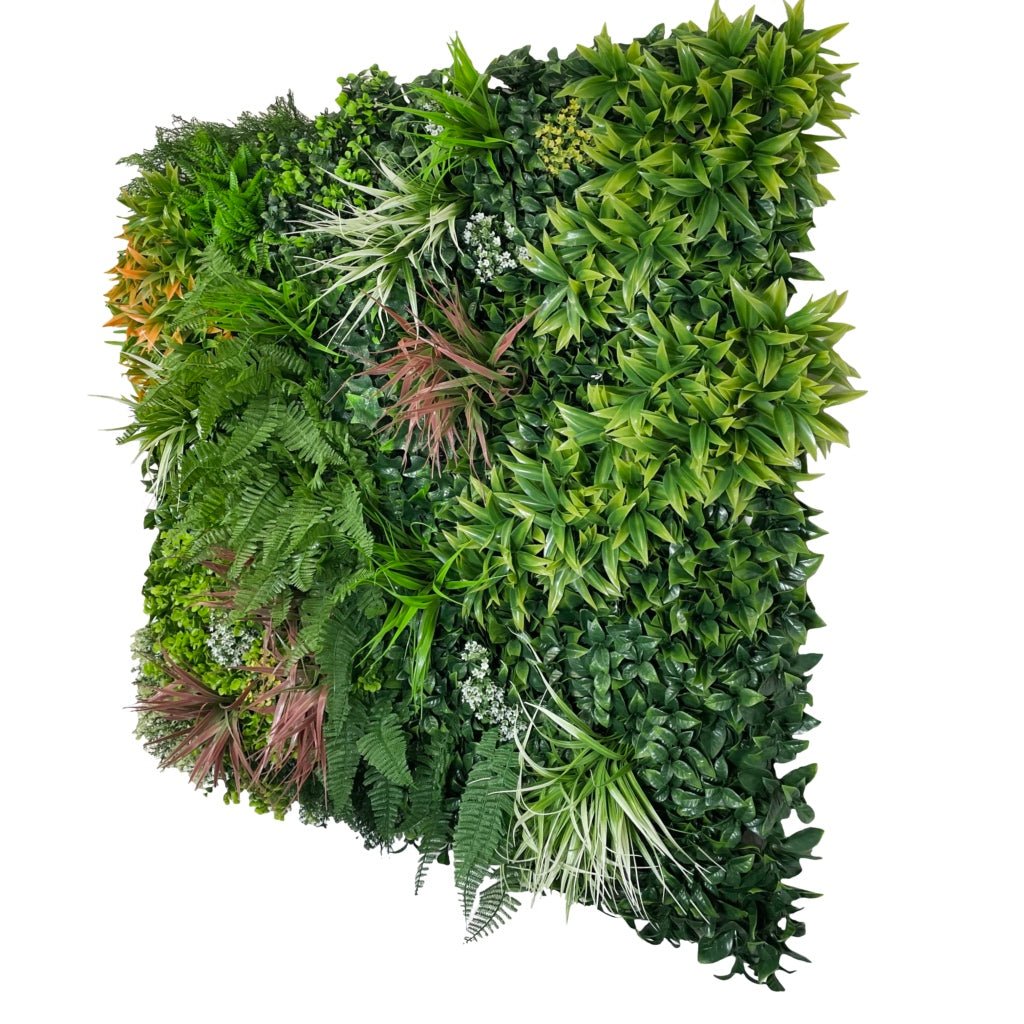 Dense green artificial foliage wall panel with mixed leaves and scattered white blossoms