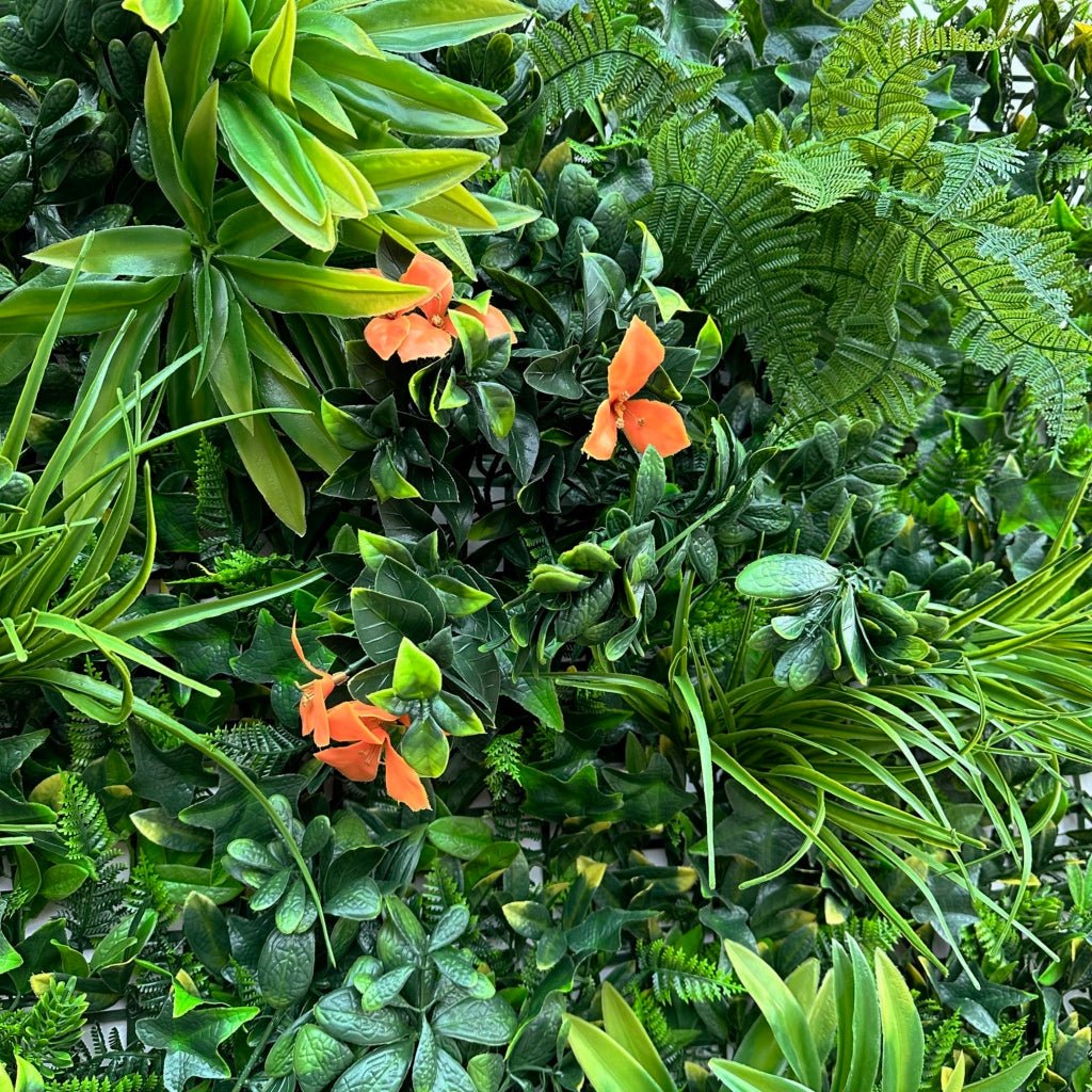 Artificial foliage wall panel detail with green leaves and small orange flowers