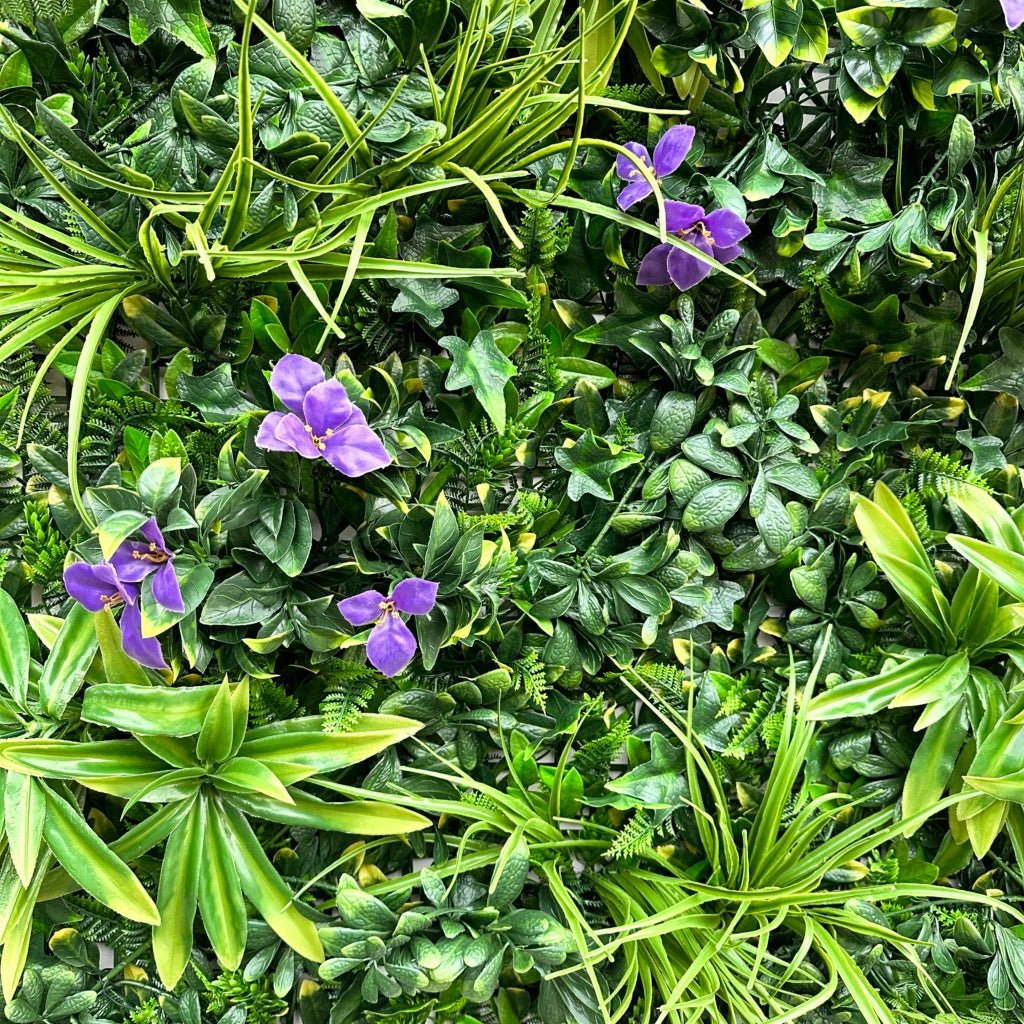Artificial foliage wall panel close-up with variegated green leaves and purple blooms
