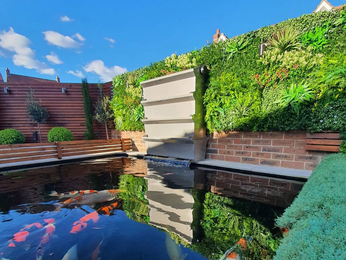 Artificial green foliage wall panel along the wall with bright green layered leaves