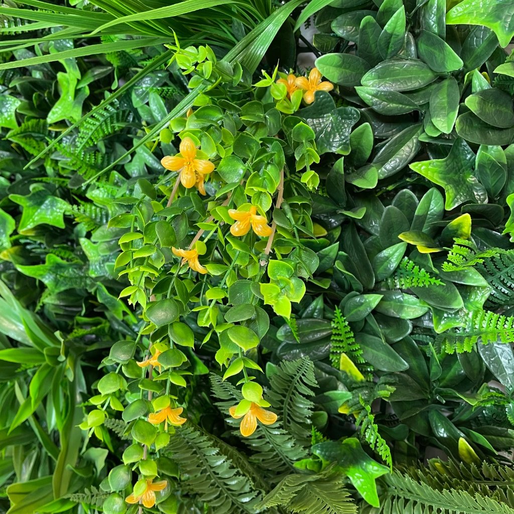 Artificial wall panel close-up of glossy green leaves with small yellow flowers