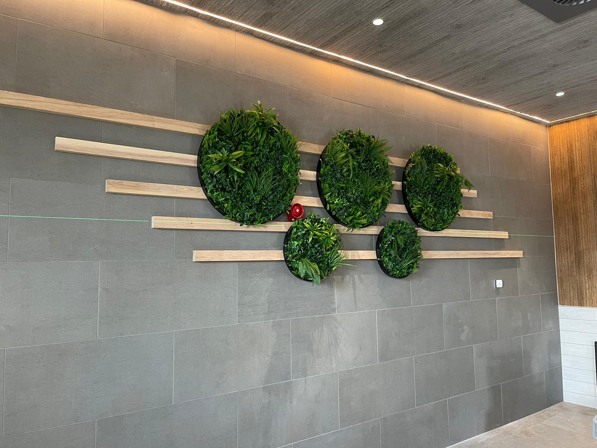 Multiple circular artificial foliage wall panels on a stone tile wall