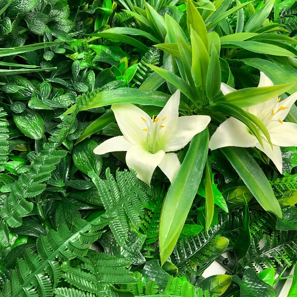 Artificial green wall panel with white lilies and mixed variegated foliage, close-up
