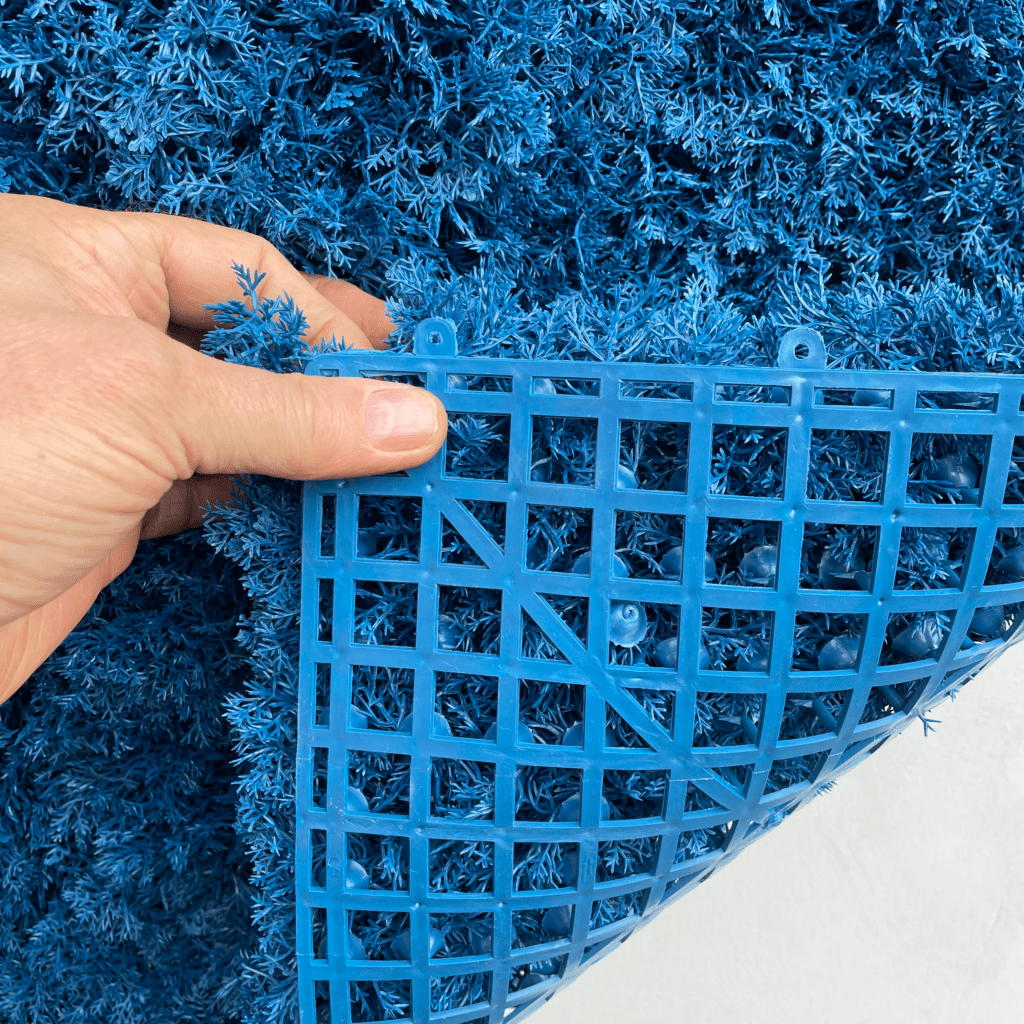 Blue artificial reindeer moss panel with curved plastic grid backing, corner view