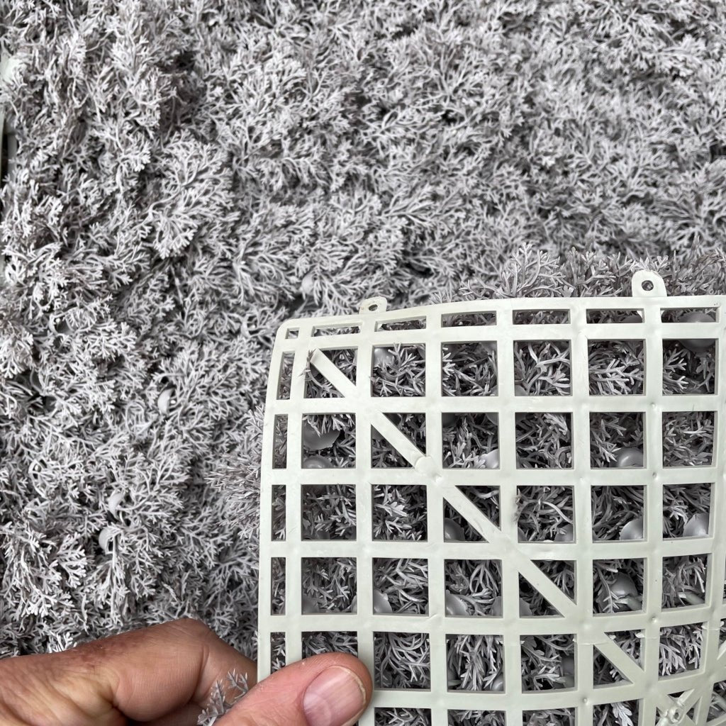 Grey reindeer moss panel with white lattice backing, held by hand