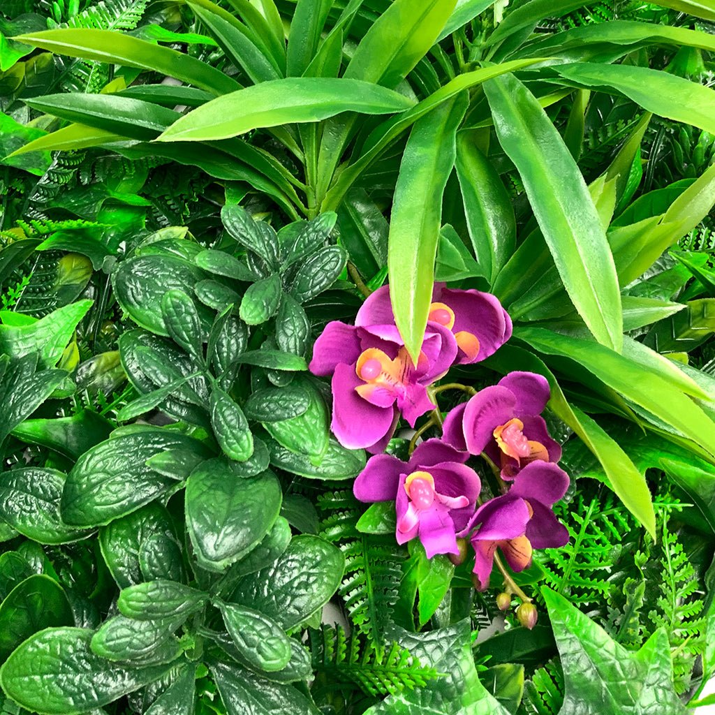 Artificial foliage wall panel close-up with purple orchid blooms and green leaves