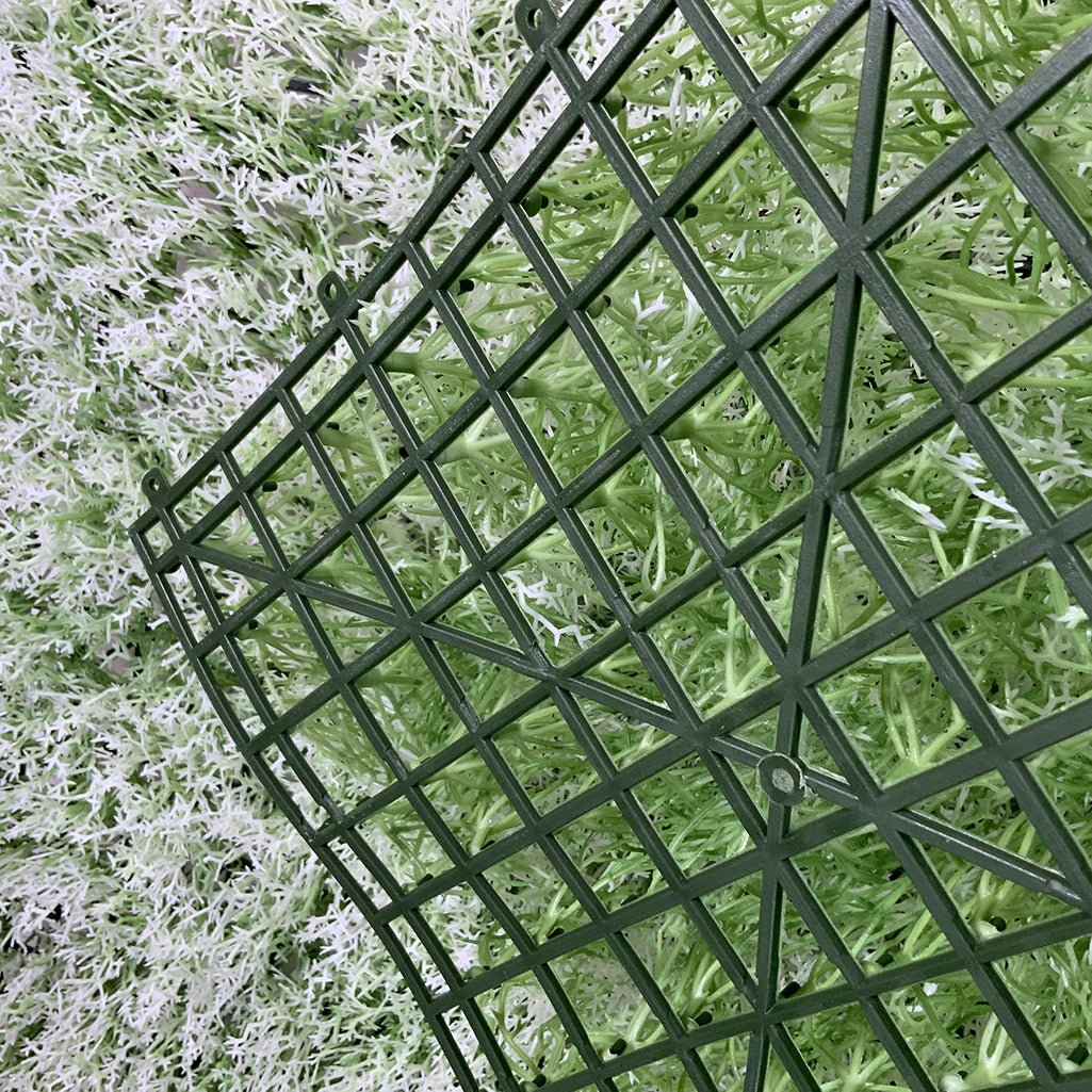 Artificial moss panel corner with dark grid backing and tufted moss surface.