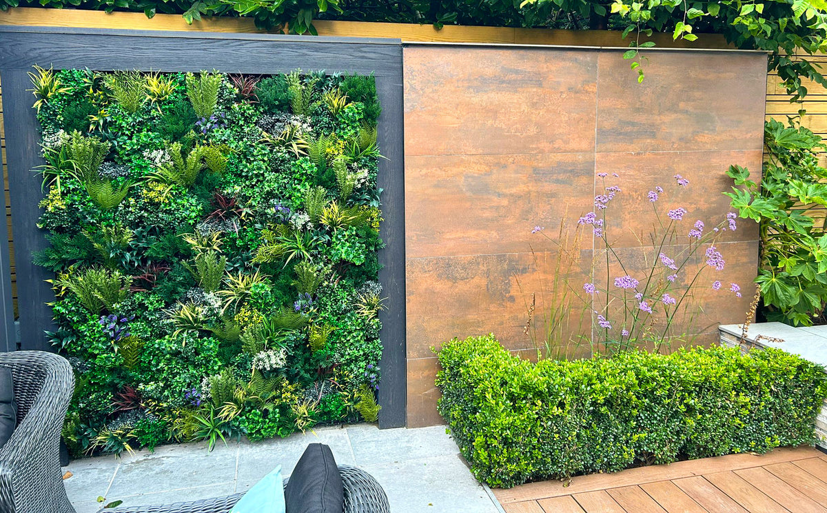 Artificial foliage wall panel with bright green leaves and small purple flowers