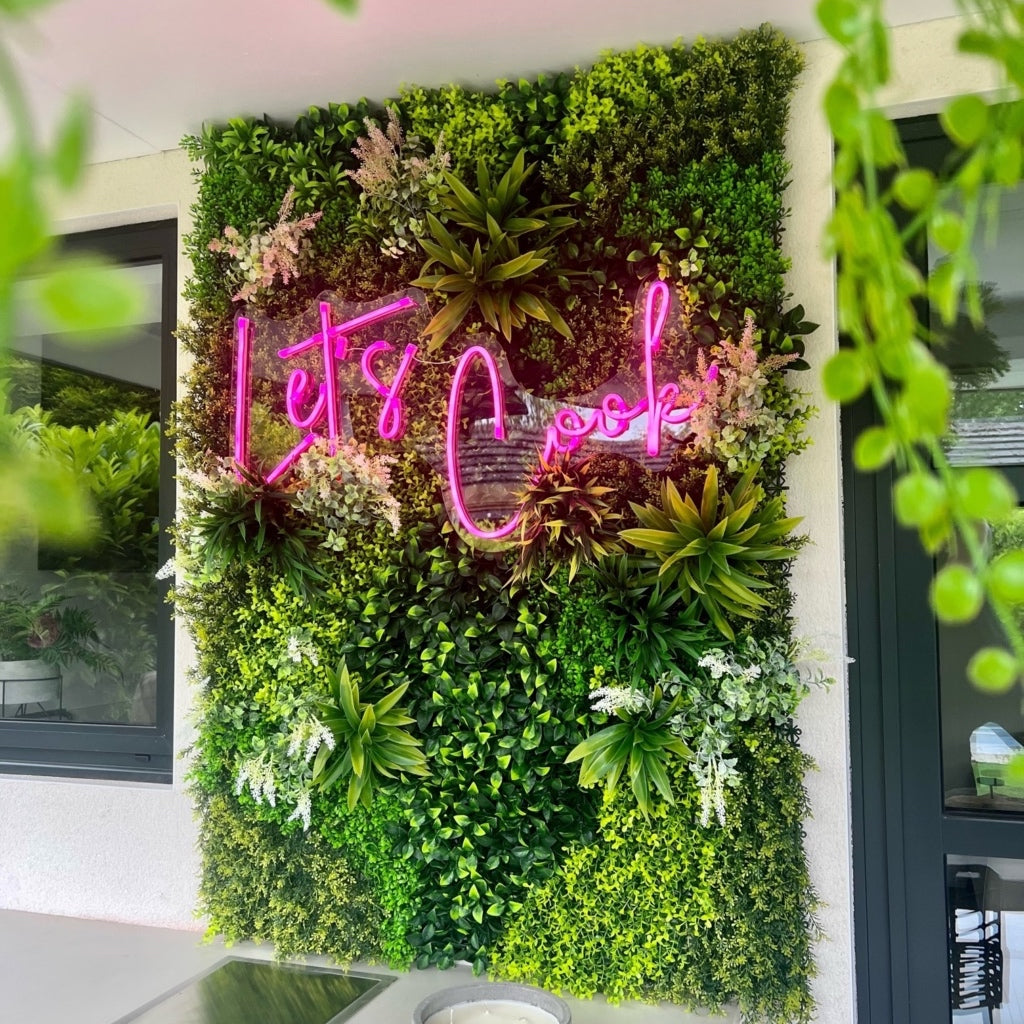 Artificial green wall panel with variegated foliage and purple and white flowers