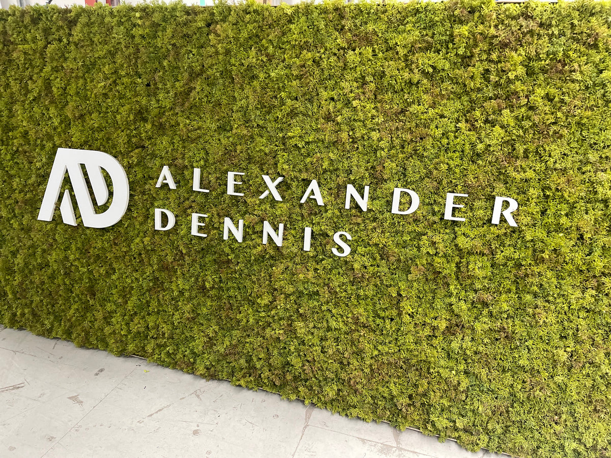 Artificial moss panel with Alexander Dennis logo on green turf surface