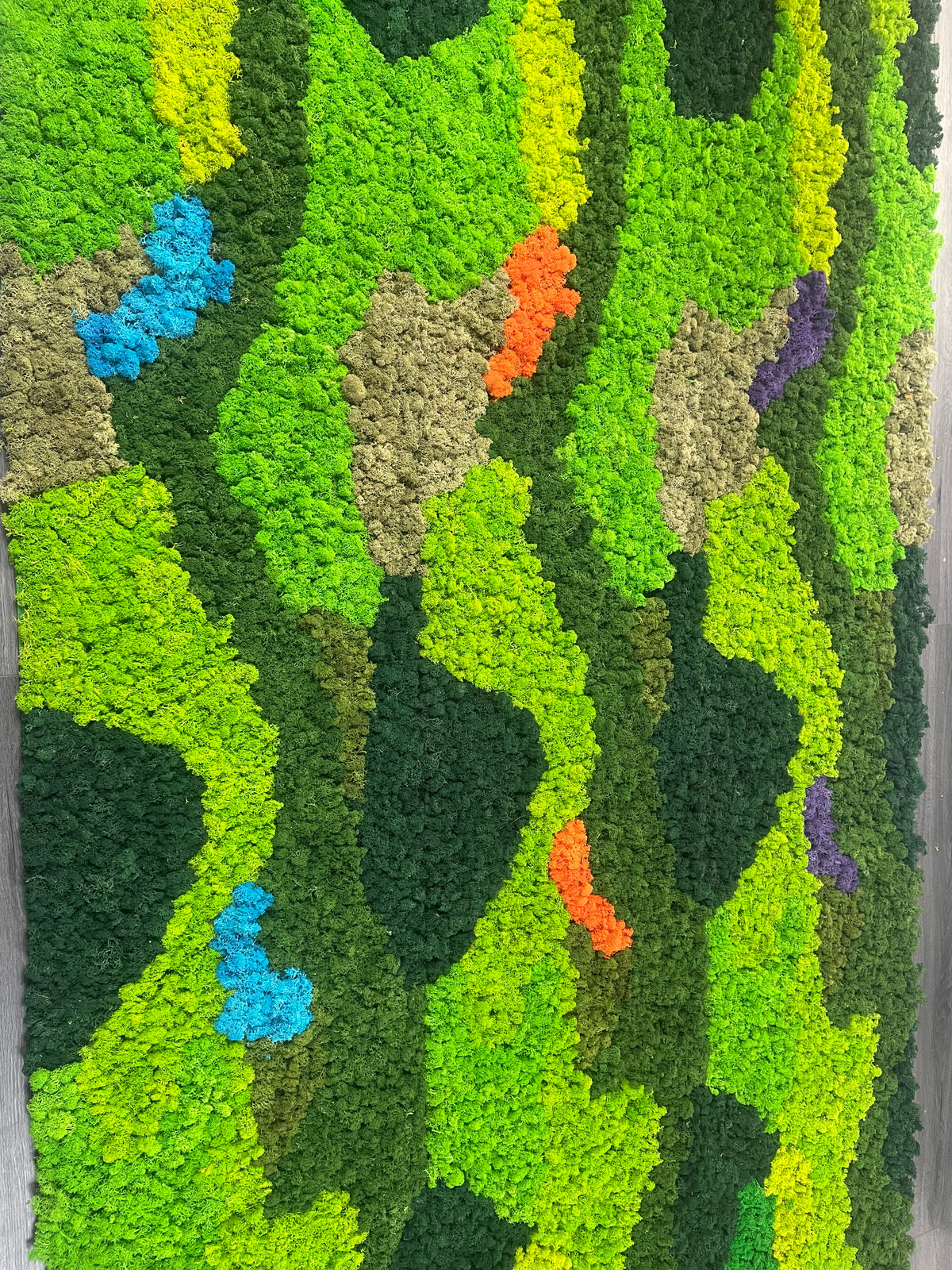 Preserved reindeer moss panel close-up with bright green zigzag, plus blue, orange, and purple