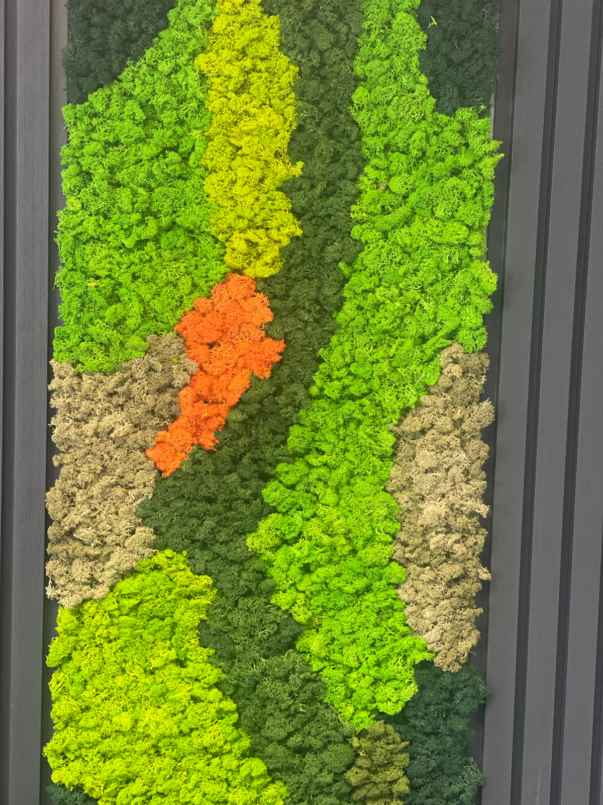 Preserved reindeer moss panel with lime green blocks, beige waves, and two orange moss highlights.