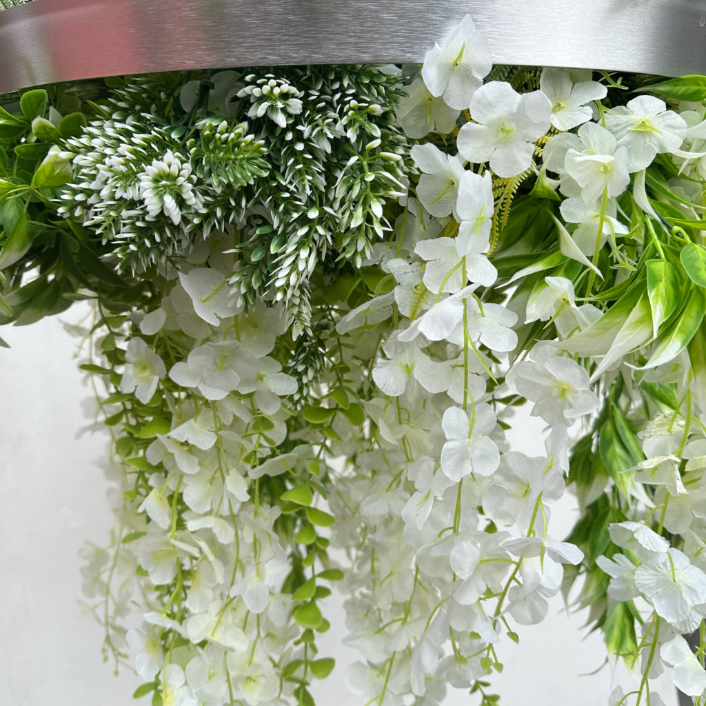 Hanging hoop with a mixture of artificial green plants with white trailing flowers 60cm diameter