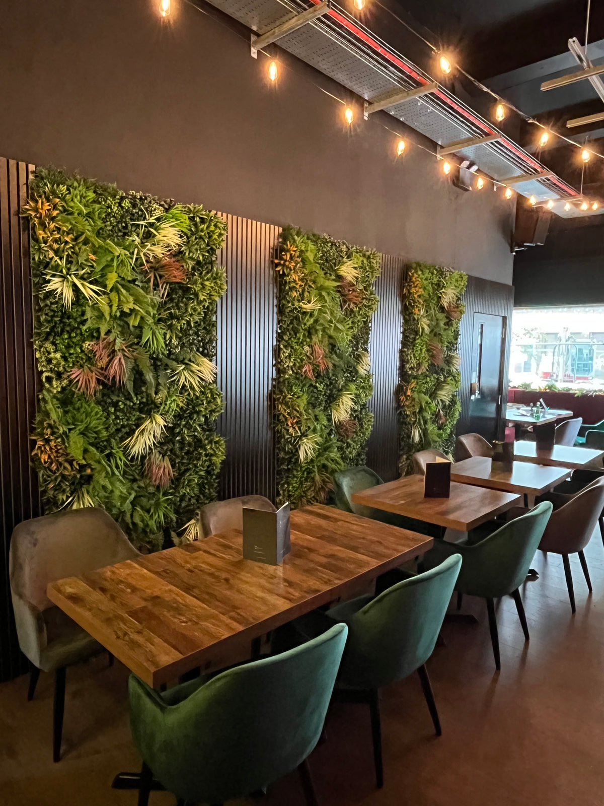 Artificial green wall panel with dense vertical greenery and varied leaf textures