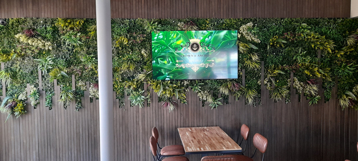 Artificial green wall panel with variegated greens of ivy, ferns, palm heads, grasses & yellow tipped privets 100x100 cm