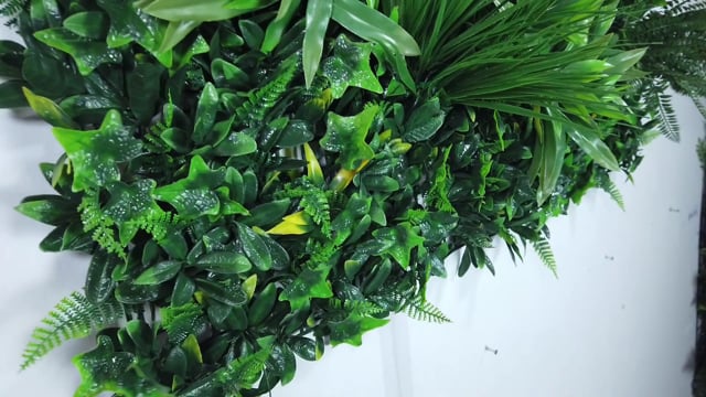 Artificial green wall panel with variegated greens of ivy, ferns, palm heads, grasses & yellow tipped privets  100x100 cm