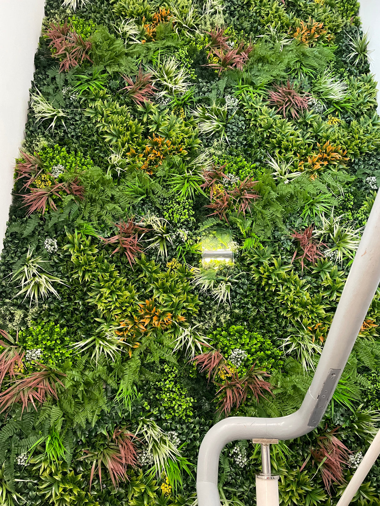 Artificial green wall panel with mixed green orange red and white foliage, white and yellow flowers 100x100 cm