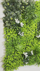 Artificial green wall panel with variegated green foliage  palms grasses eucalyptus and white flowers 100x100 cm