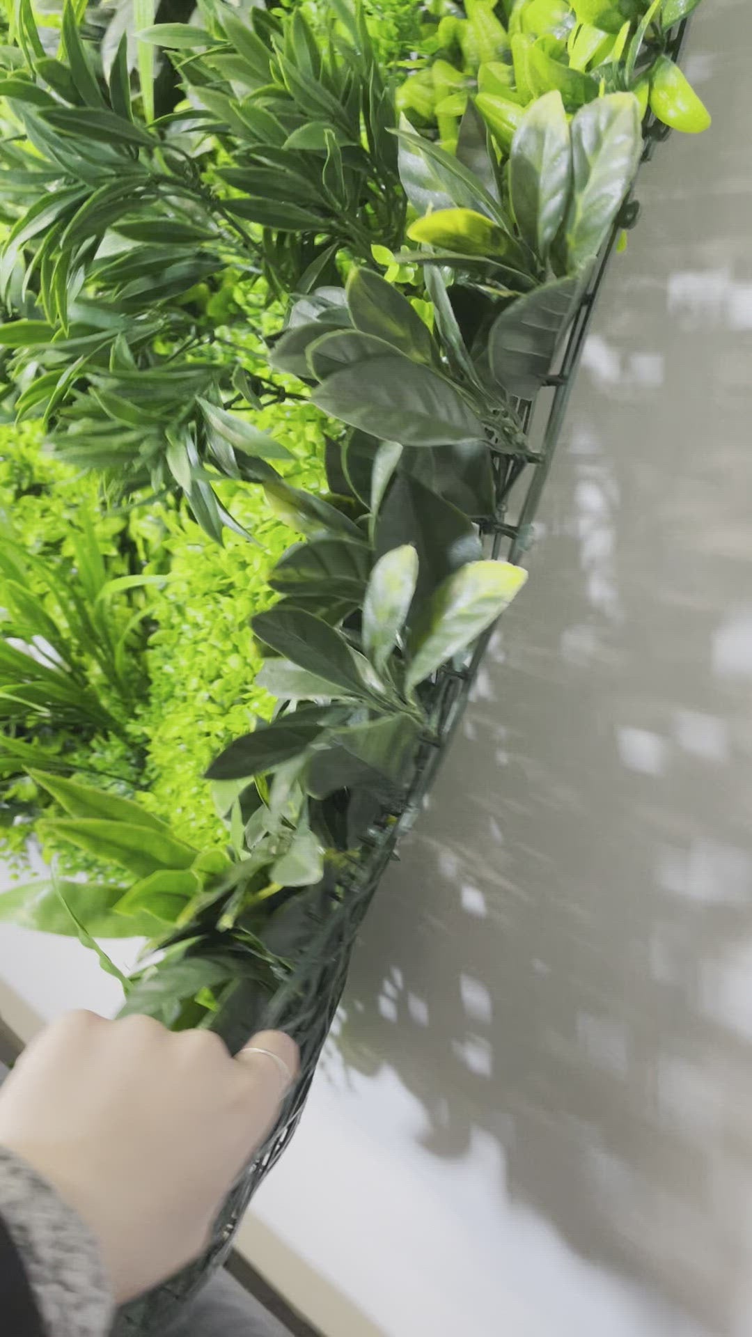 Artificial green wall panel with variegated green foliage  palms grasses eucalyptus and white flowers 100x100 cm