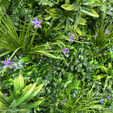 Artificial green wall panel with variegated greens of ivy, ferns, palm heads, grasses & small purple flowers  100x100 cm