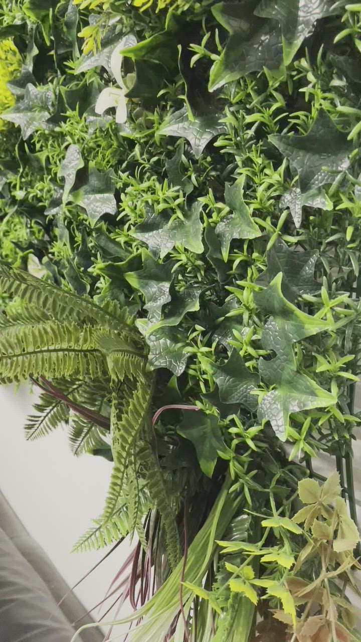 Artificial green wall panel with variegated green, red,  white & yellow foliage with ferns, palm heads, grasses & white flowers  100x100 cm