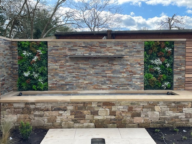 Artificial green wall panel with variegated greens of ivy, ferns, palm heads, grasses