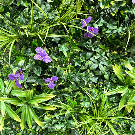 Artificial green wall panel with variegated foliage ivy palms grasses and ferns with purple flowers 100x100 cm