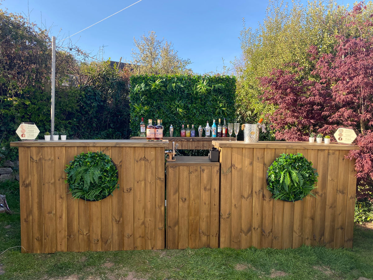 Circular artificial foliage wall panels mounted on a wooden outdoor fence