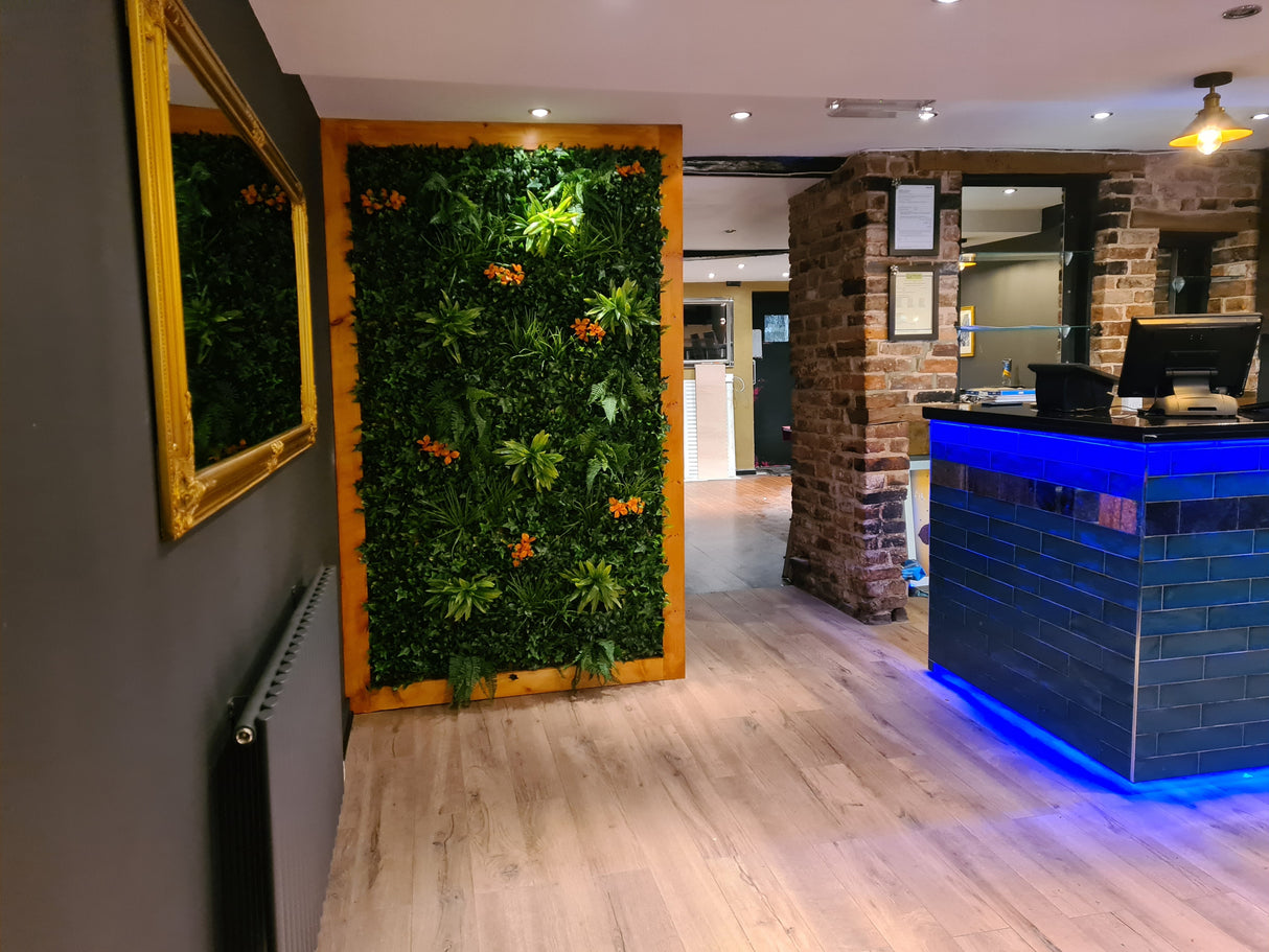 Artificial green wall panel with variegated foliage ivy palms grasses and ferns with orange flowers 100x100 cm